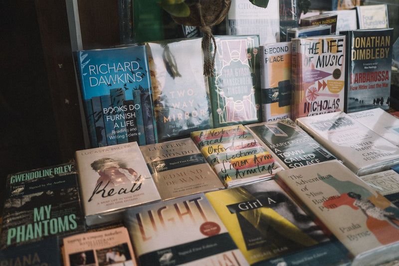 Colourful book covers displayed face out on shelves in a bright bookshop