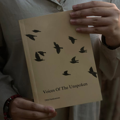 Book titled 'Voices Of The Unspoken' held by a person