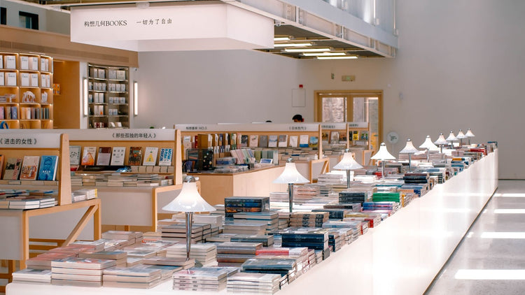 Bright modern bookshop interior with white display tables and neatly stocked shelves