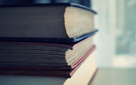 Close-up of a neat stack of hardback books resting on a bright table