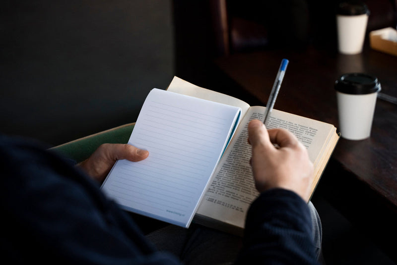 A hand holding a notebook